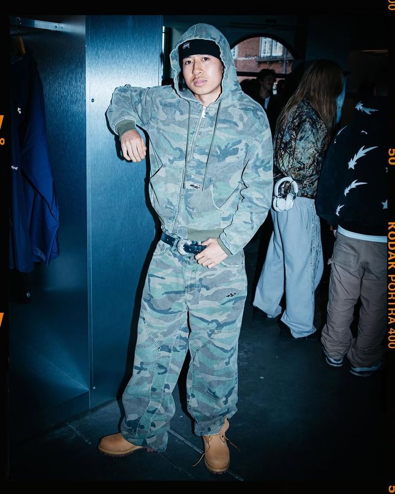 A guest in a camouflage hoodie and trousers with Timberland boots at the Timberland × Rezet evening event.