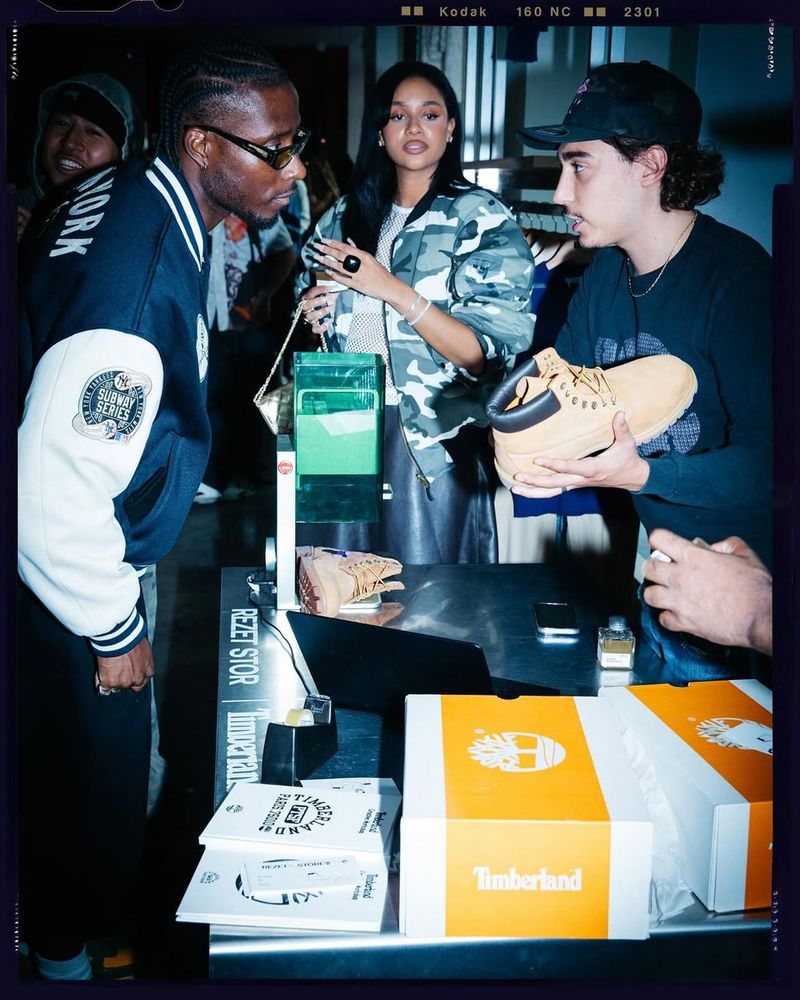 Guests gather around a counter with Timberland boot boxes and a Rezet Store sign.